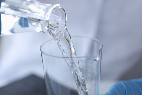 person checking water quality in beaker
