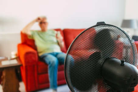 man with fan during heatwave